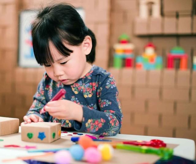 A child crafts with corrugated boxes